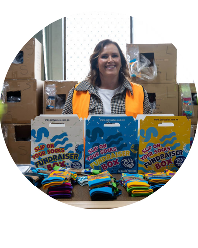 Tanya owner standing with fundraiser sock boxes in front